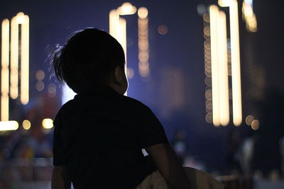 A baby enjoying city view at night