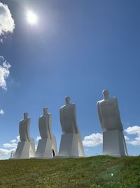 Low angle view of sculpture on field against sky