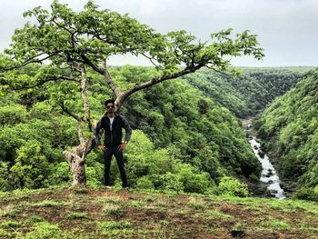 Man standing amidst trees in forest