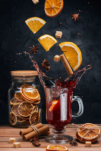 Falling mulled wine ingredients, citrus fruits, cinnamon and star anise fly from a height 