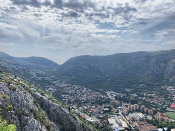 Aerial view of townscape and mountains against sky