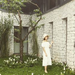 Portrait of woman standing against plants