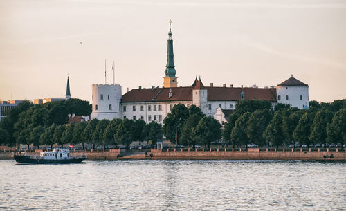 View of river by buildings against sky