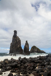 Rocks by sea against sky