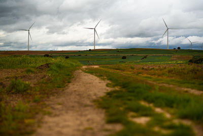 Wide shot of sustainable windmills at a farm field in valdorros in castile and leon, burgos, spain. 