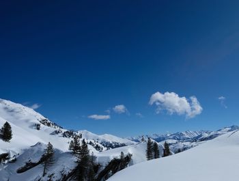 Scenic view of snowcapped mountains against blue sky