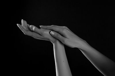 Close-up of woman hand over black background