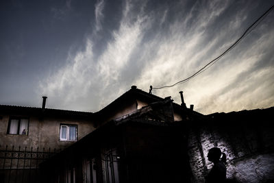 Low angle view of silhouette buildings against sky