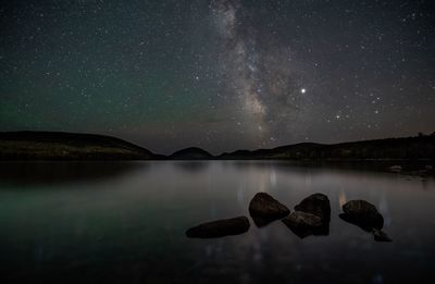 Scenic view of lake against sky at night