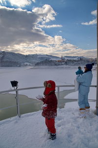 Rear view of women walking on snow covered mountain