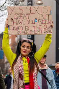 Woman standing with text against the wall