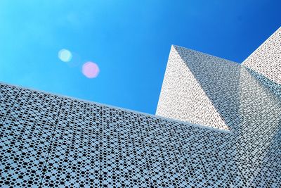 Low angle view of modern building against clear blue sky on sunny day