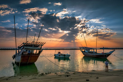 Sailboats in sea against sky during sunset