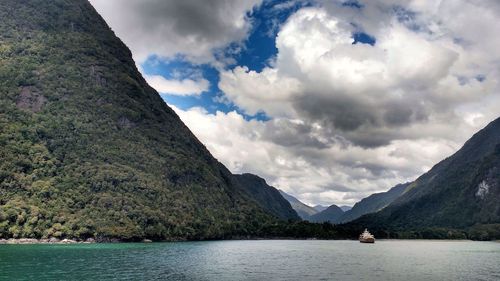 Scenic view of sea and mountains against sky