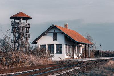 View of railroad tracks by building against sky