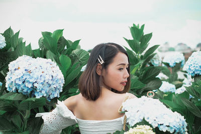 Woman standing amidst flowers blooming in garden