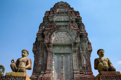 Low angle view of statue against building against clear sky