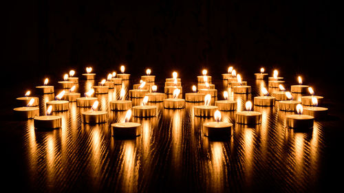 Candles burning against black background