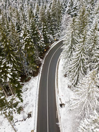 Winding road through the forest, from high mountain pass, winter.
