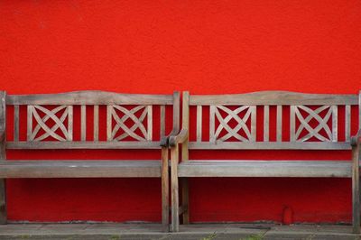 Empty chairs against red wall in building