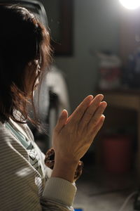 Side view of senior woman praying at home