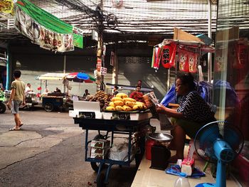 People sitting at market stall