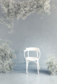 High angle view of empty chair by lake during winter