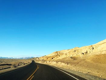 Scenic view of road against clear blue sky