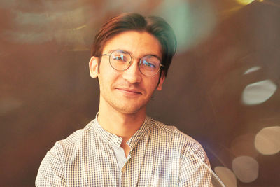 Portrait of young man standing against wall