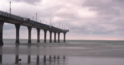 Pier over sea against sky during sunset