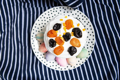 Easter eggs and easter cake are on a plate, lying on a striped blue apron. easter religious holiday 