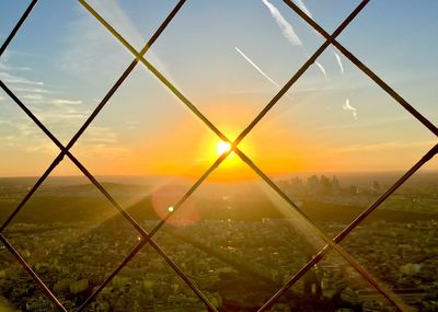 Fence on field against sky during sunset