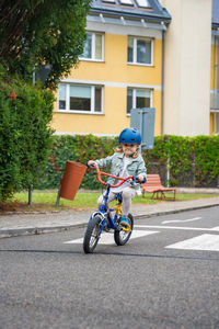 Side view of man riding push scooter on road