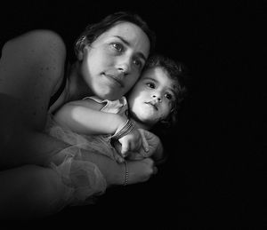 High angle view of mother with daughter against black background