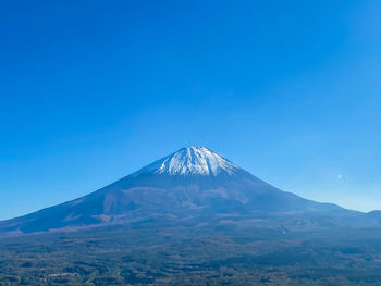 Scenic view of snowcapped mountains against blue sky