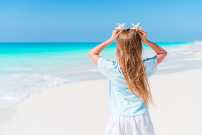 Rear view of girl standing on beach