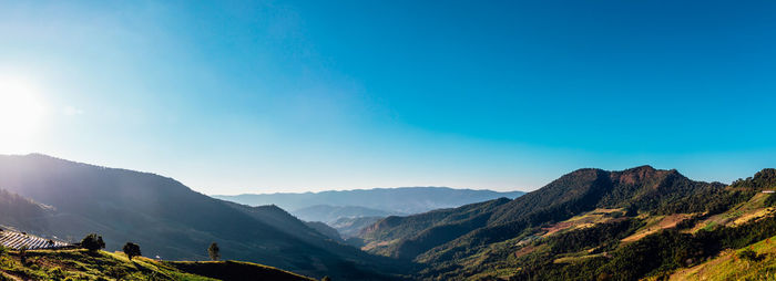 Scenic view of mountains against blue sky