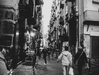 People walking on street amidst buildings in city