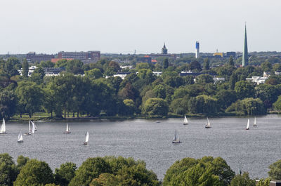 Scenic view of river by city against clear sky