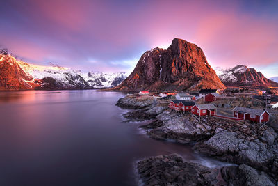 Scenic view of lake and rocky mountains against sky during sunset