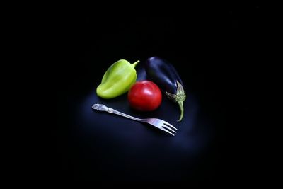 Close-up of tomatoes on table against black background
