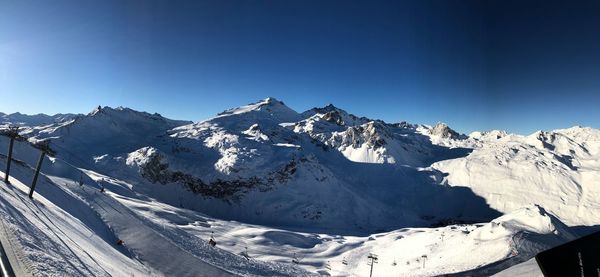 Scenic view of snowcapped mountains against clear blue sky