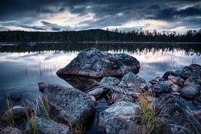 Rocks in lake against sky