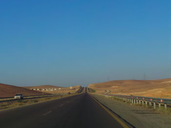 Road on landscape against clear blue sky