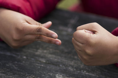 Cropped hands of children gesturing on table