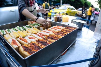 Midsection of woman holding food in container