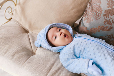 Portrait of cute baby lying on bed