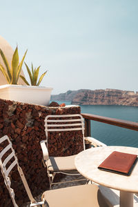 Potted plant on table by sea against sky