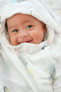 Portrait of cute baby girl lying on bed