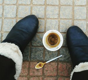 Directly above shot disposable cup amidst human legs at street